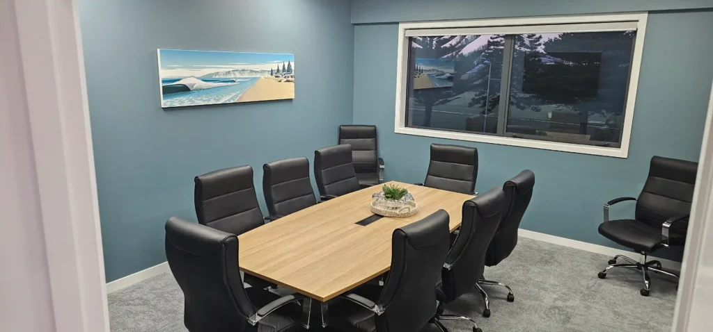 Midway Hub boardroom with eight seats, display screen and beach artwork, meeting room hire Gisborne