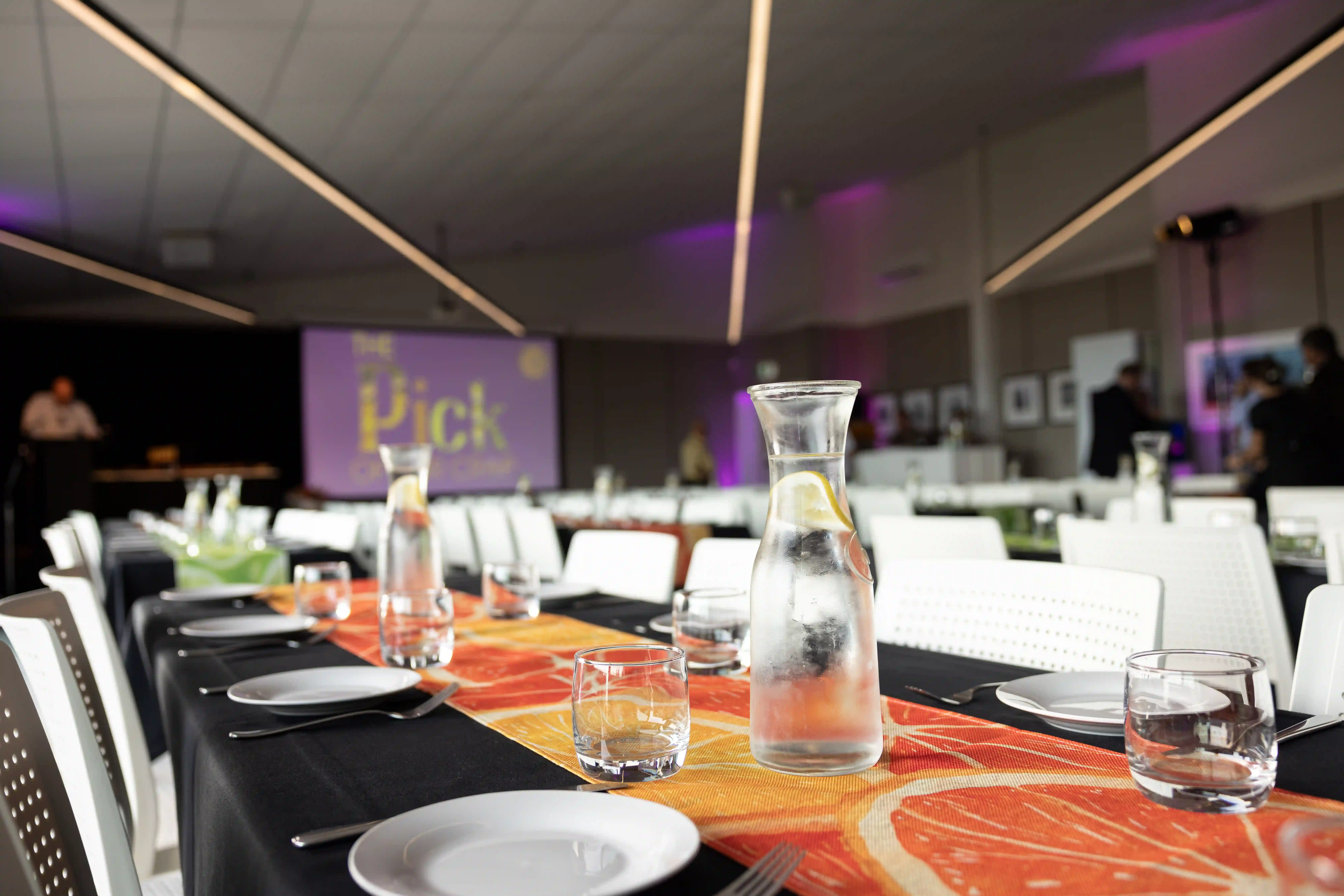 Corporate event dinner setup with purple uplighting at full-service venue Gisborne