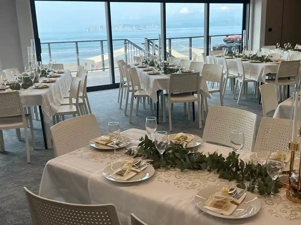 Wedding reception with round tables and greenery centrepieces overlooking the ocean at a Gisborne venue