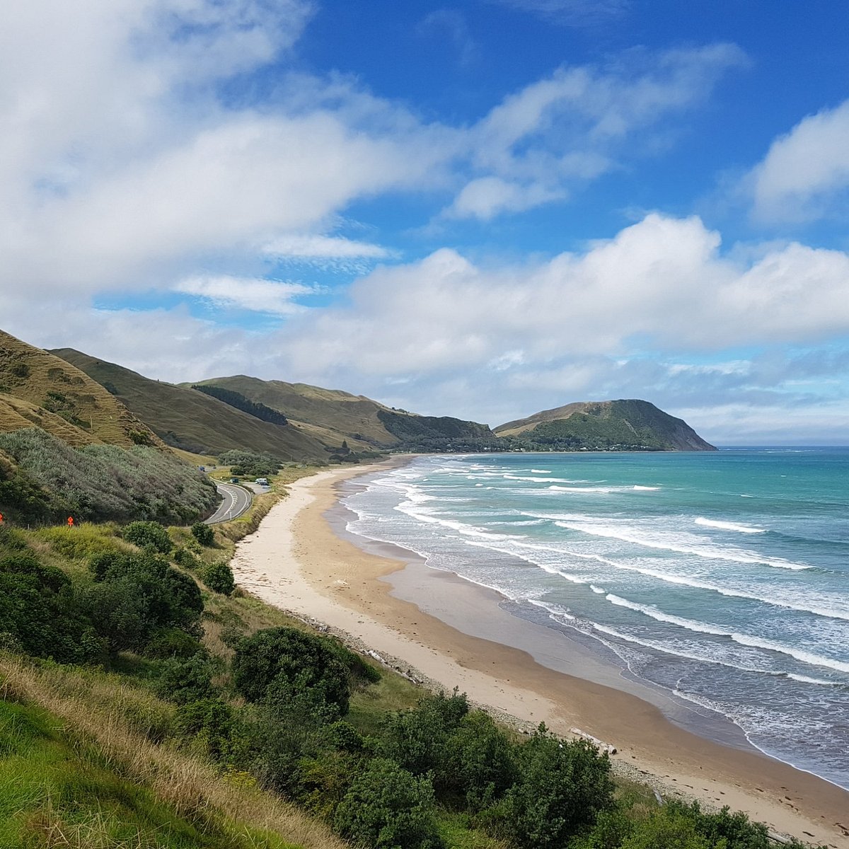 Makorori Beach with turquoise waves and green hills on the Gisborne coast New Zealand