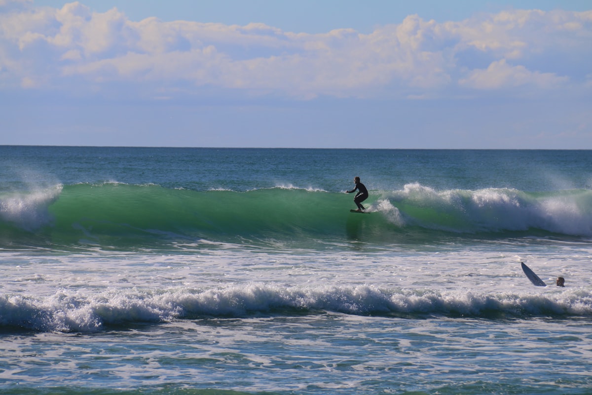 Surfers catching waves at Wainui Beach Gisborne