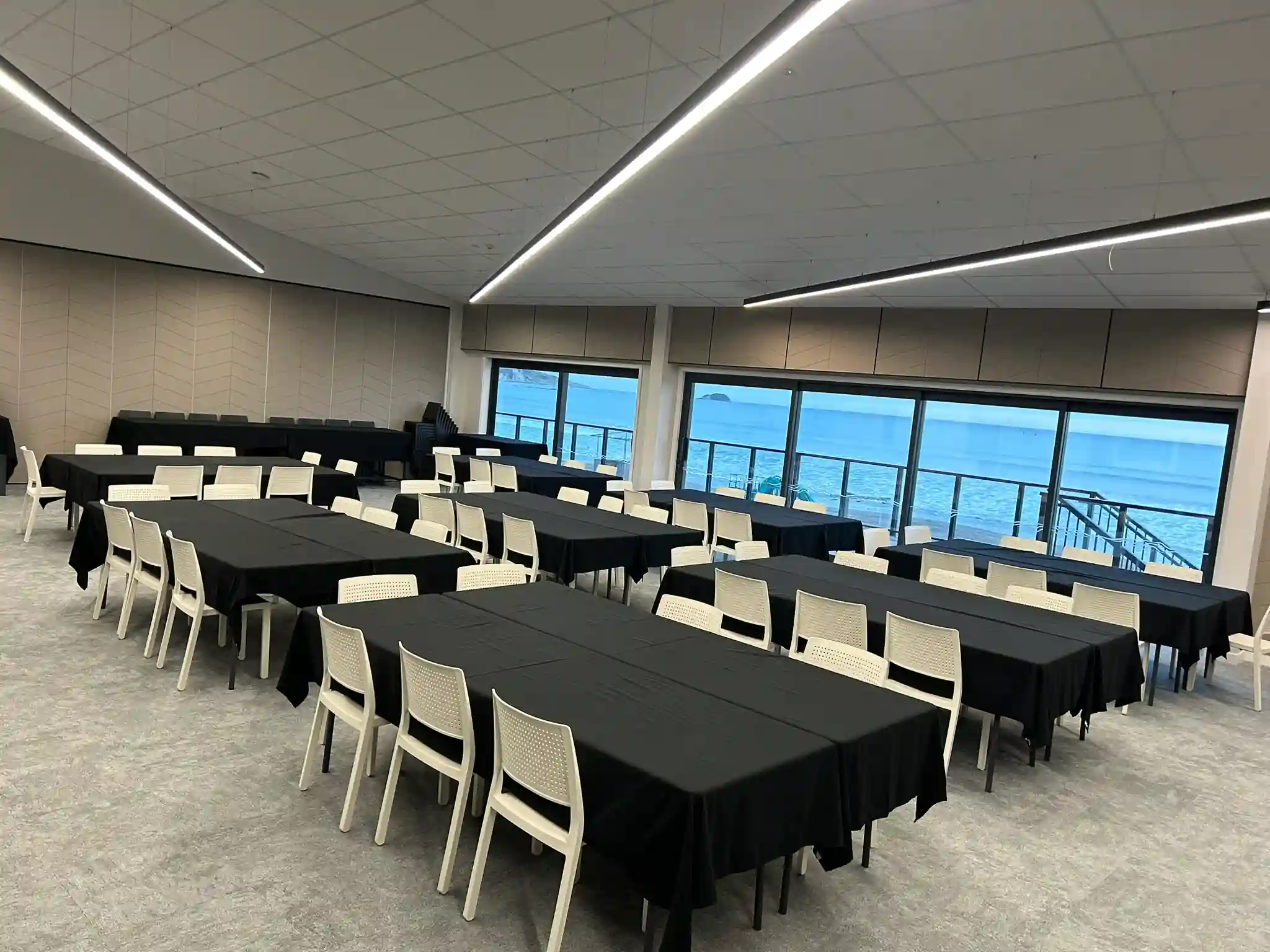Classroom style table layout in Midway Hub function room with ocean view windows for non-profit training events Gisborne