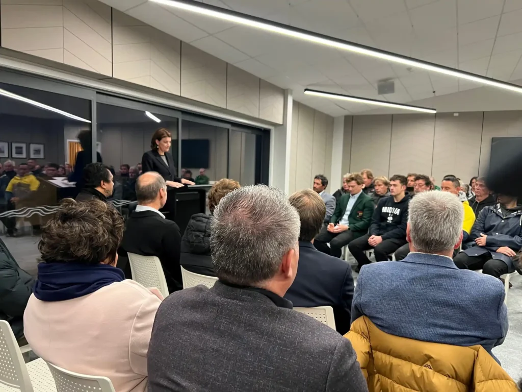 Community event with speaker at podium and seated audience at Midway Community Hub Gisborne