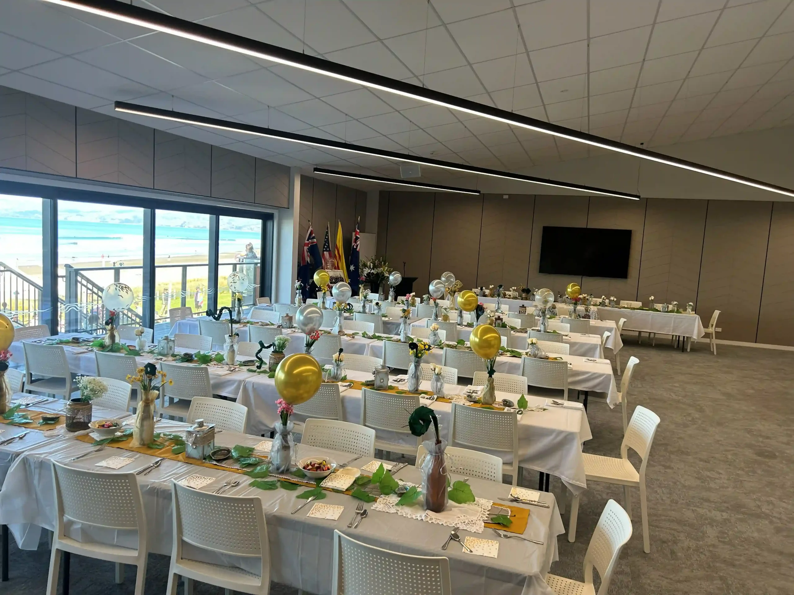 Large staff Christmas celebration with white tables and balloons at a New Zealand venue